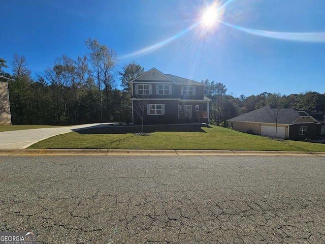 view of front of house with a garage, concrete driveway, and a front lawn