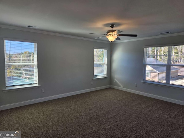 spare room featuring carpet floors, baseboards, visible vents, and crown molding