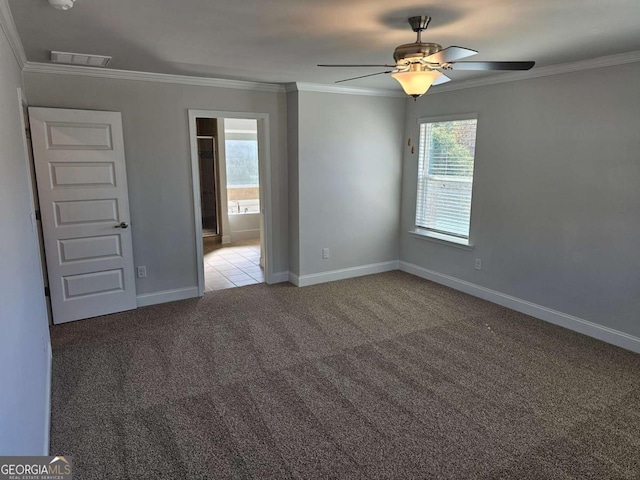 unfurnished bedroom with baseboards, visible vents, ensuite bathroom, crown molding, and carpet floors