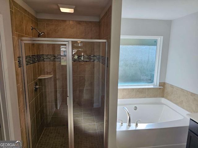 bathroom with a stall shower, vanity, and a bath