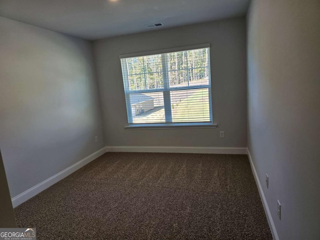 carpeted spare room with visible vents and baseboards