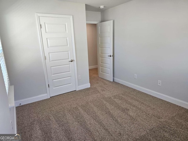 unfurnished bedroom with carpet floors and baseboards