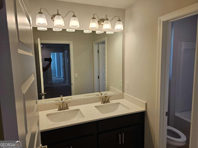 full bathroom with a sink, toilet, and double vanity