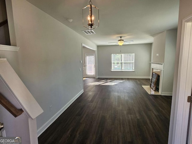 unfurnished living room featuring ceiling fan, dark wood-type flooring, a premium fireplace, visible vents, and baseboards