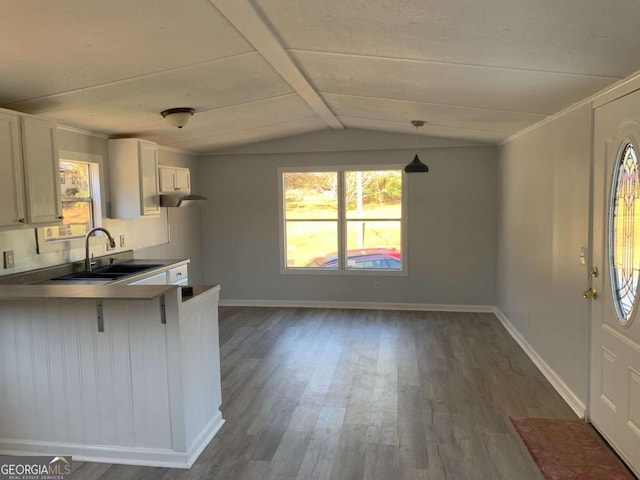 kitchen featuring decorative light fixtures, sink, white cabinetry, and dark wood-type flooring