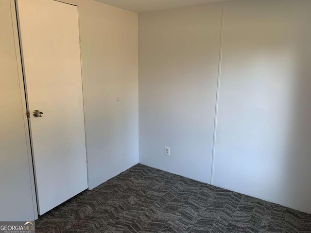 unfurnished bedroom with dark colored carpet