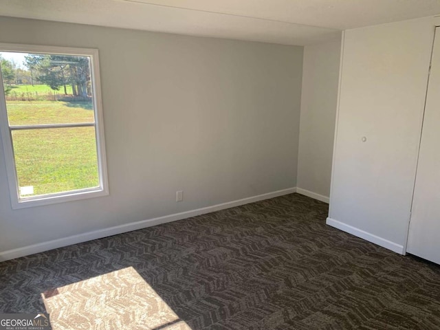 empty room with dark colored carpet