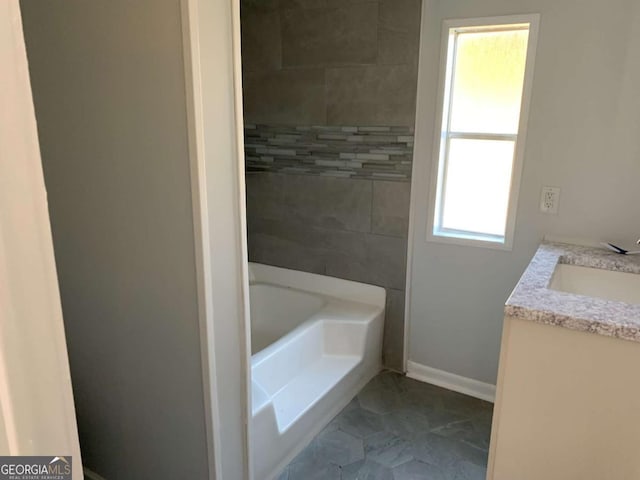 bathroom with a tub to relax in and vanity