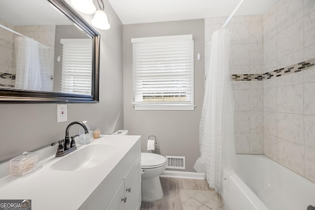 full bathroom featuring hardwood / wood-style floors, vanity, toilet, and shower / bathtub combination with curtain