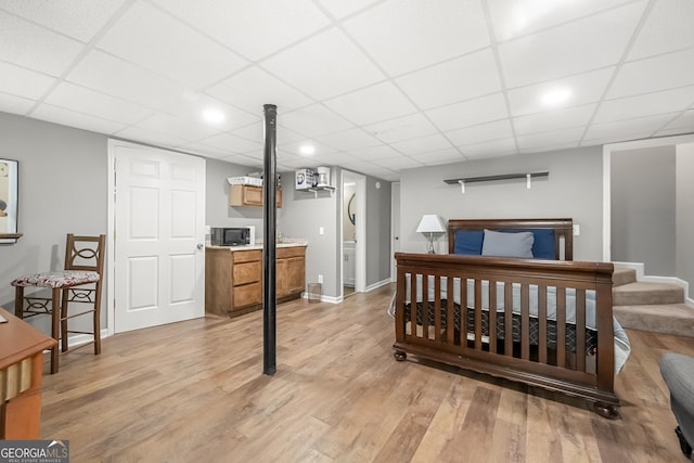 bedroom with light hardwood / wood-style flooring and a drop ceiling