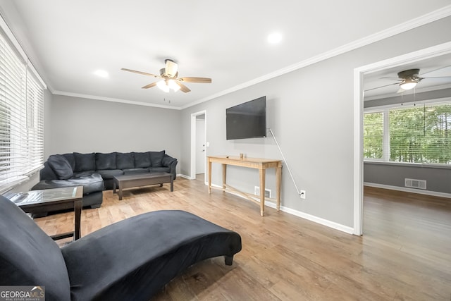 living room with crown molding, ceiling fan, and light wood-type flooring