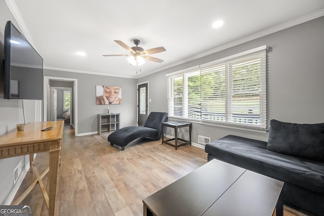 living room with ornamental molding, a wealth of natural light, and light hardwood / wood-style flooring