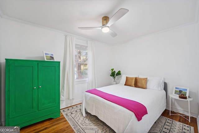 bedroom featuring dark hardwood / wood-style floors, ceiling fan, and crown molding