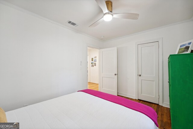 bedroom with ceiling fan, ornamental molding, and hardwood / wood-style flooring