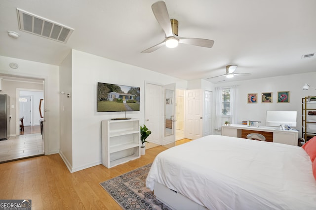 bedroom featuring stainless steel fridge, ceiling fan, and light hardwood / wood-style flooring