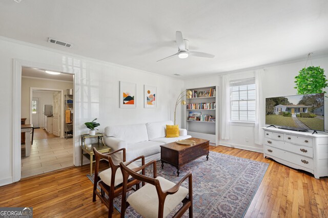 sitting room featuring ceiling fan, light hardwood / wood-style floors, and ornamental molding