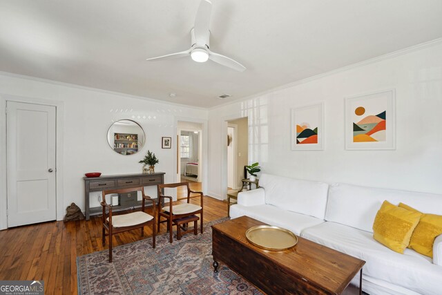 living room featuring ceiling fan, crown molding, and dark wood-type flooring