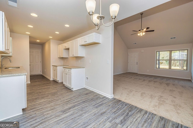 kitchen with white cabinetry, a sink, visible vents, and baseboards