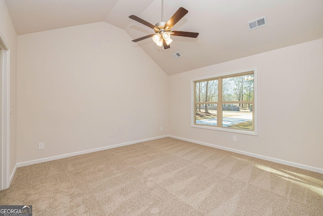 empty room featuring lofted ceiling, carpet floors, visible vents, and baseboards