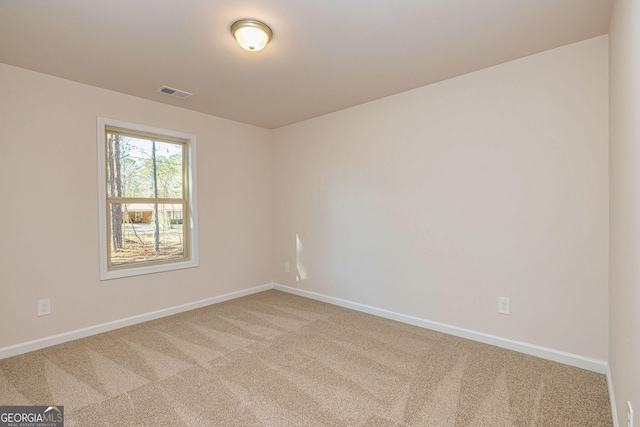 carpeted empty room featuring baseboards and visible vents