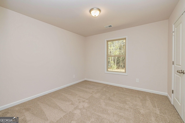 carpeted empty room featuring visible vents and baseboards