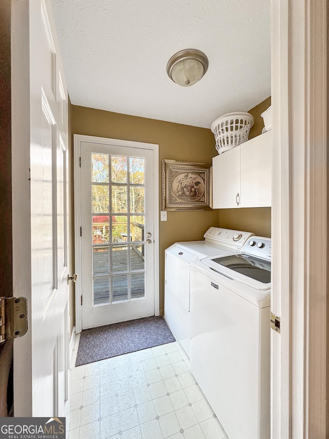 laundry area with independent washer and dryer, cabinets, and a textured ceiling