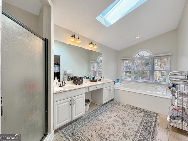 bathroom featuring lofted ceiling with skylight, independent shower and bath, tile patterned flooring, and vanity