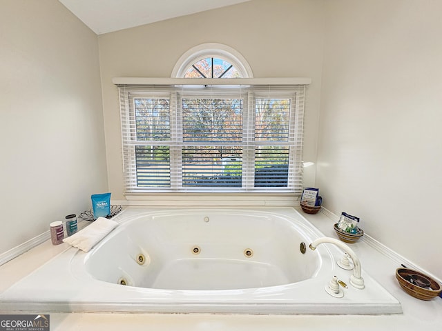 bathroom with a relaxing tiled tub