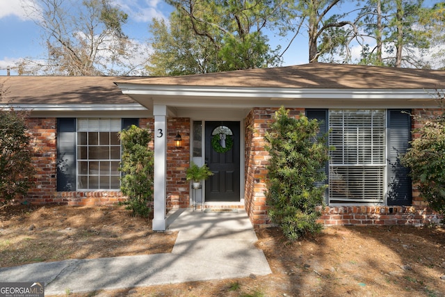 doorway to property with brick siding