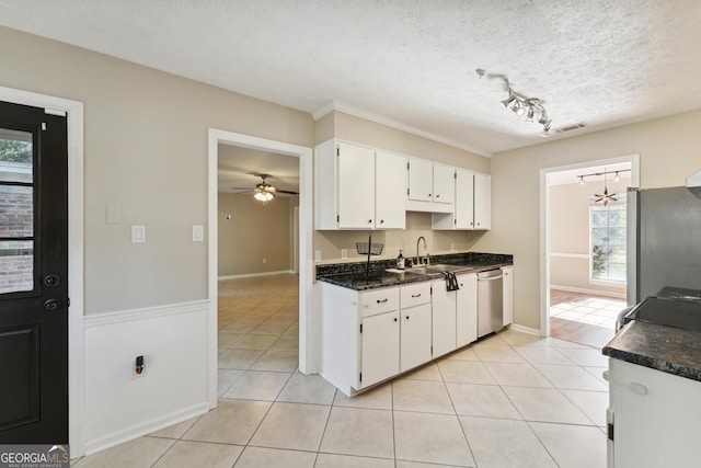 kitchen with sink, stainless steel appliances, white cabinets, and light tile patterned flooring