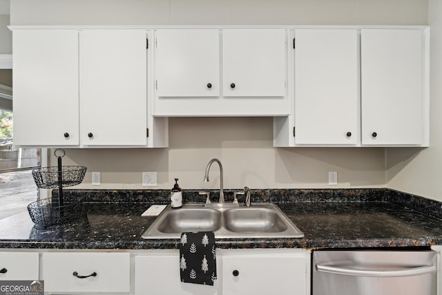 kitchen featuring white cabinetry, dark stone counters, dishwasher, and a sink