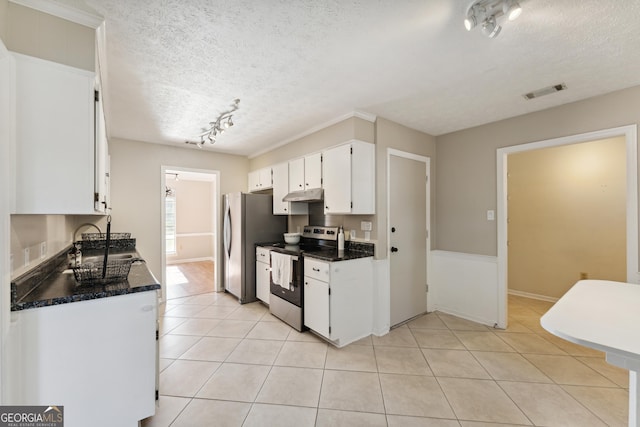 kitchen featuring visible vents, dark countertops, appliances with stainless steel finishes, white cabinets, and light tile patterned flooring