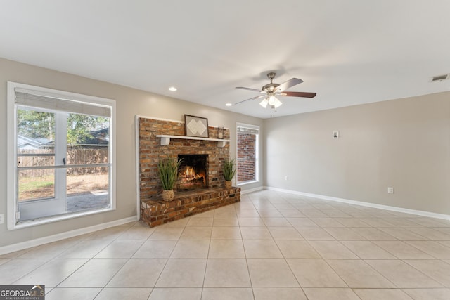 unfurnished living room with a brick fireplace, ceiling fan, and light tile patterned flooring