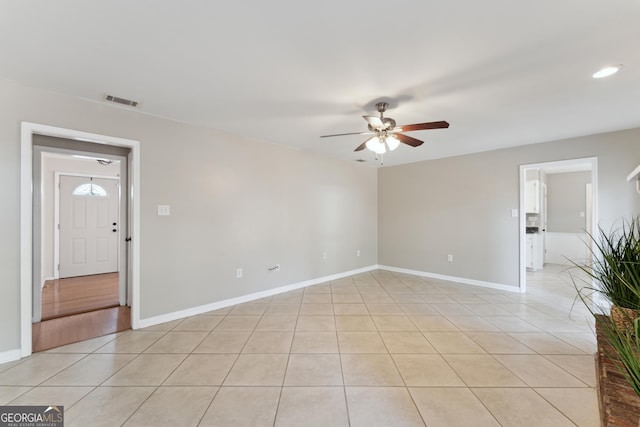 tiled spare room featuring ceiling fan