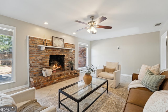 living room featuring tile patterned floors, visible vents, recessed lighting, a fireplace, and baseboards