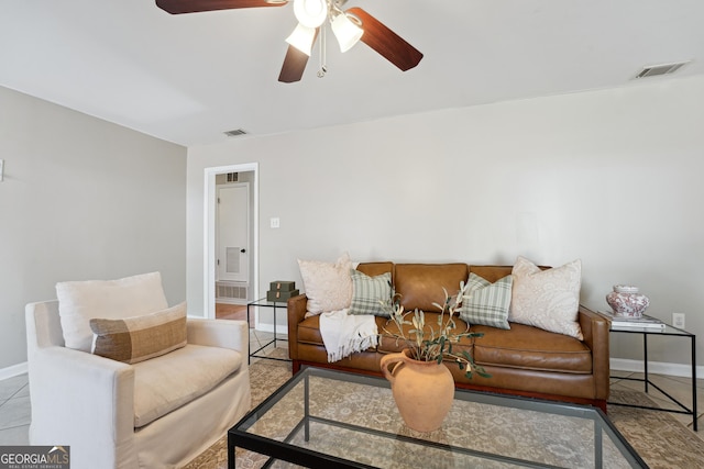 tiled living room with visible vents, a ceiling fan, and baseboards