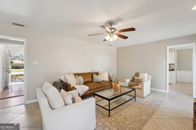 living area with visible vents, baseboards, light tile patterned flooring, and a ceiling fan