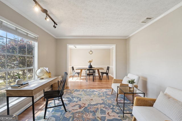 office area with visible vents, ornamental molding, a textured ceiling, and wood finished floors