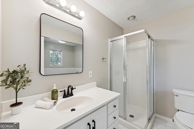 bathroom with vanity, a shower with shower door, a textured ceiling, and toilet