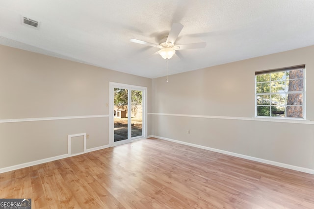 spare room with a ceiling fan, light wood-style flooring, baseboards, and visible vents