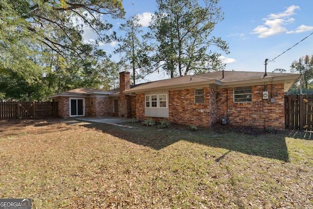 back of house featuring a patio, brick siding, and fence