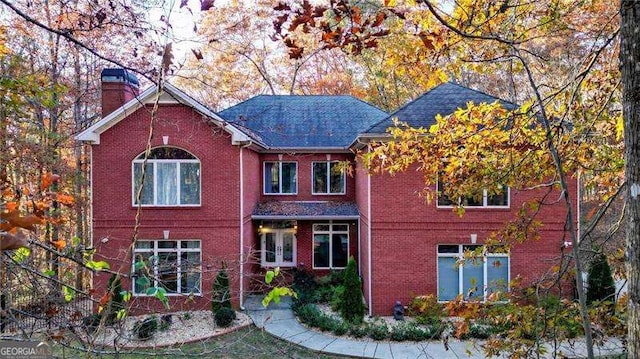 view of front of house featuring brick siding and a chimney