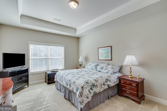 bedroom featuring a raised ceiling and light colored carpet