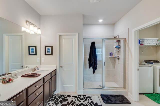 bathroom with tile patterned floors, washer and clothes dryer, vanity, and an enclosed shower