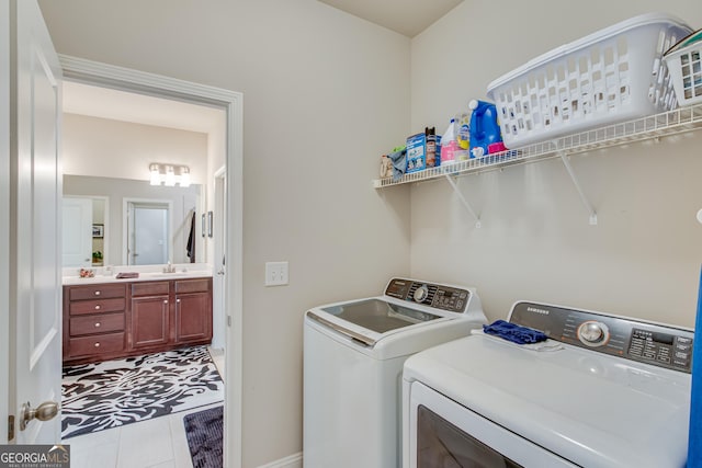 washroom featuring independent washer and dryer, sink, and light tile patterned floors