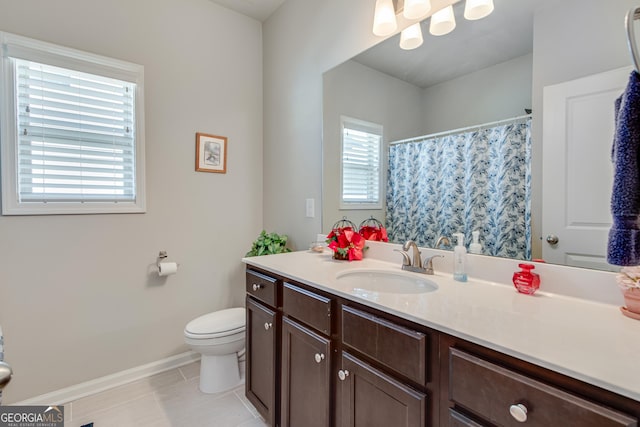 bathroom featuring tile patterned floors, plenty of natural light, vanity, and toilet