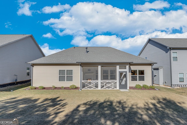 back of house featuring a sunroom and a lawn