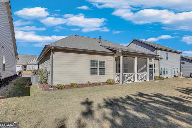 rear view of house with a sunroom, central AC unit, and a lawn