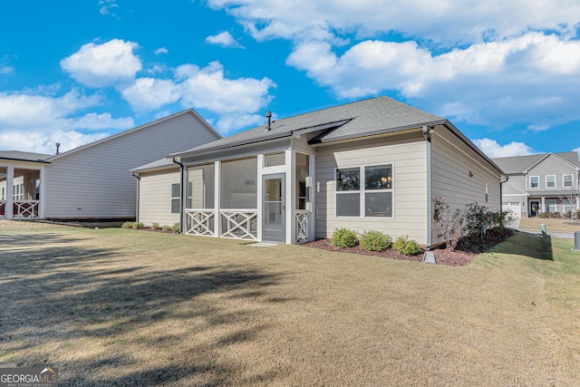 back of house with a yard and a sunroom