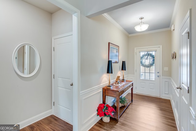 entryway with hardwood / wood-style flooring and crown molding